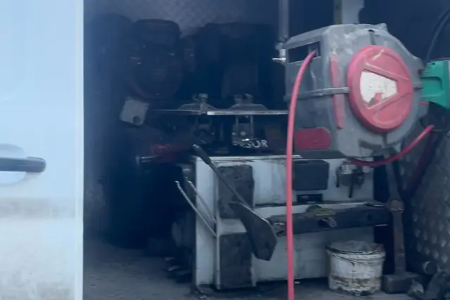 Servis aracının içinde lastik sökme makinesi, kırmızı hava hortumu makarası ve arkada istiflenmiş lastikler.